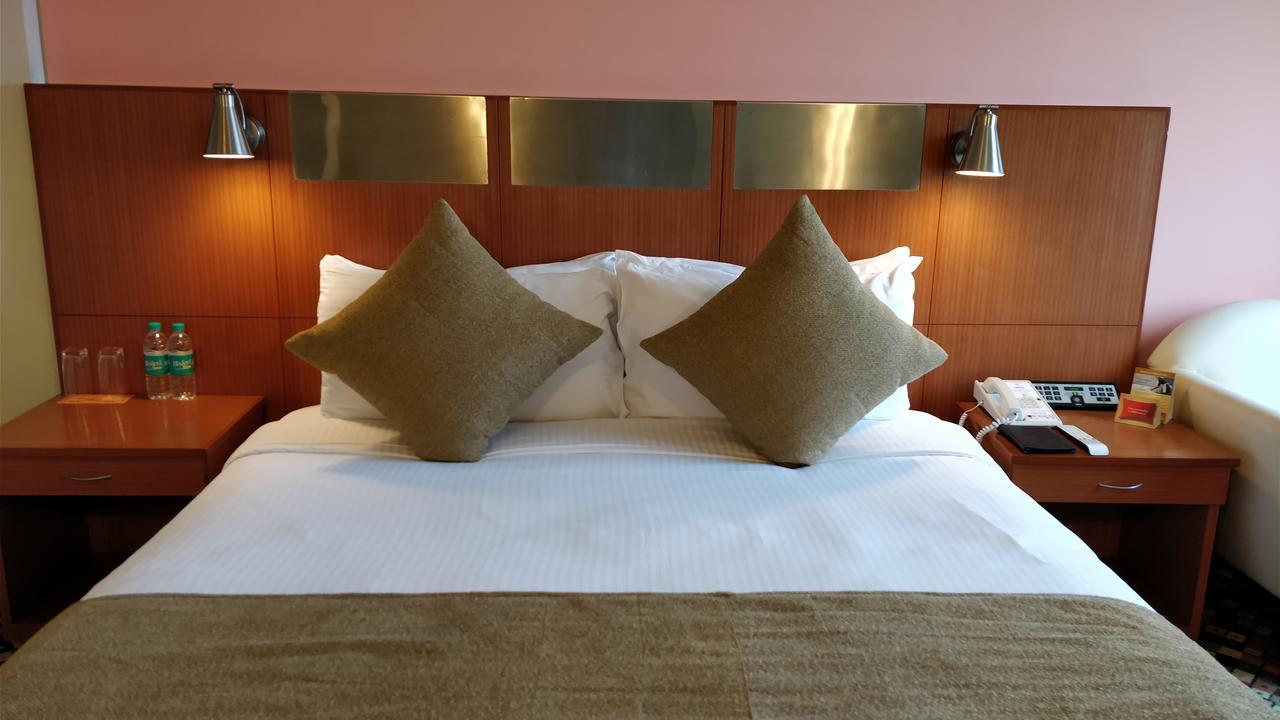 The Suryaa New Delhi Hotel Kültér fotó A bed in a hotel room