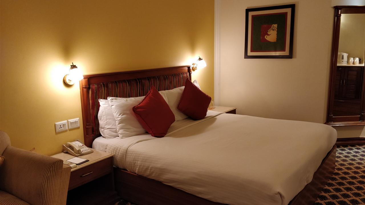 The Suryaa New Delhi Hotel Kültér fotó A bedroom at the hotel